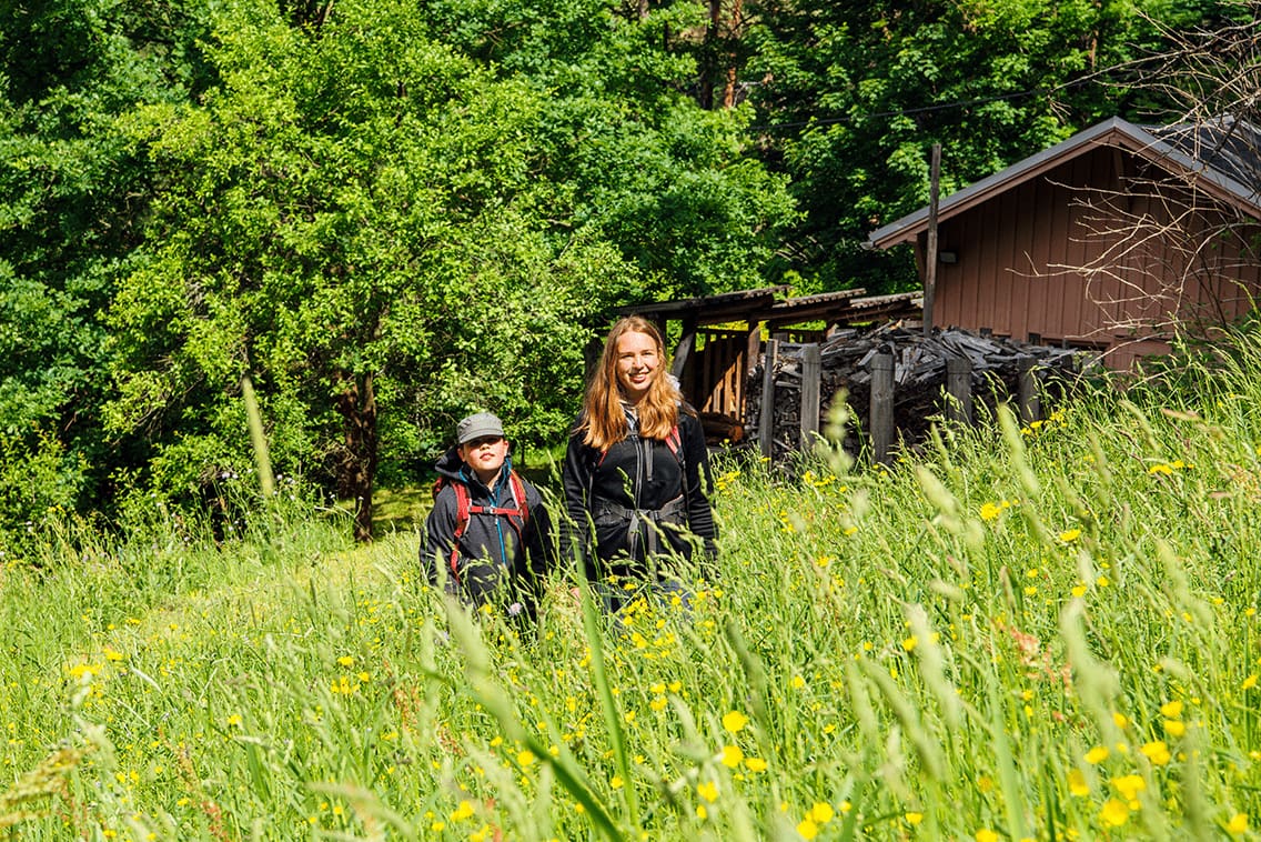 Zwei Geschwister in der Wieso beim Wandern in der Schweiz.
