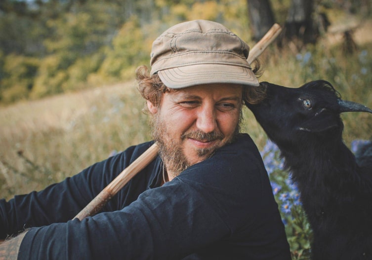 Hirte Stefan McAllister-Knöpfer mit einer seiner Jungziegen, Servus