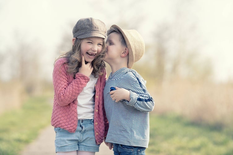 Kinder flüstern, erzählen sich Kinderwitze, lachen