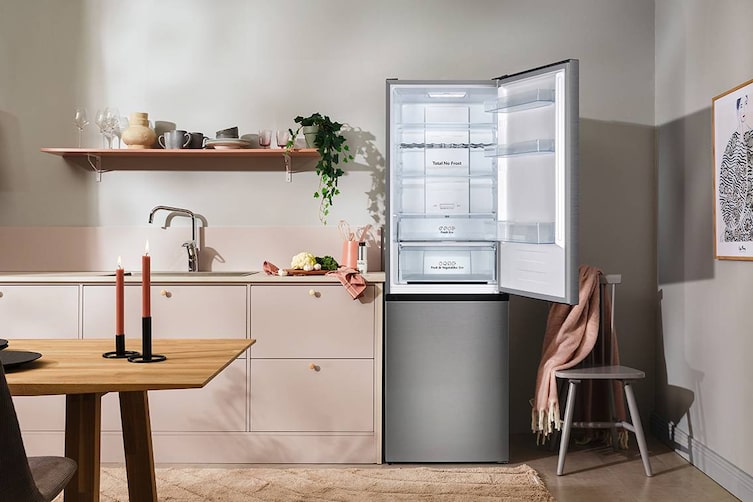 Geöffnete Elvita CKF4186X Kühl-Gefrier-Kombination in moderner, hell eingerichteter Küche mit rosa Fronten und Holzdetails