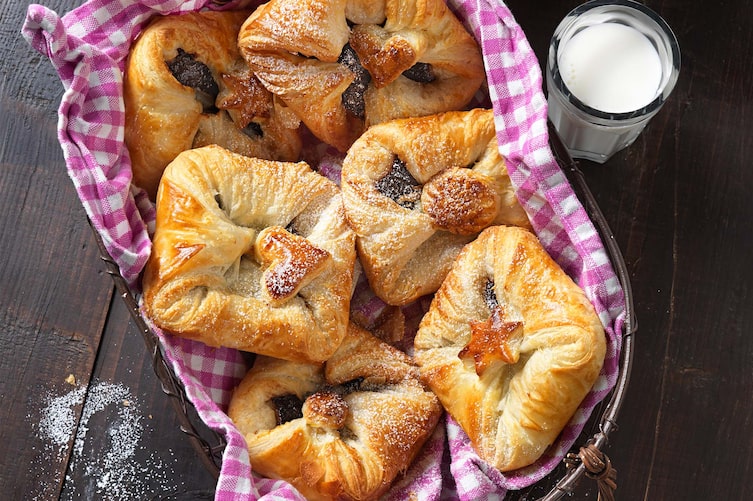 Powidlgolatschen, Germteig, Milch, Staubzucker, Küchentuch, Körbchen, Holztisch