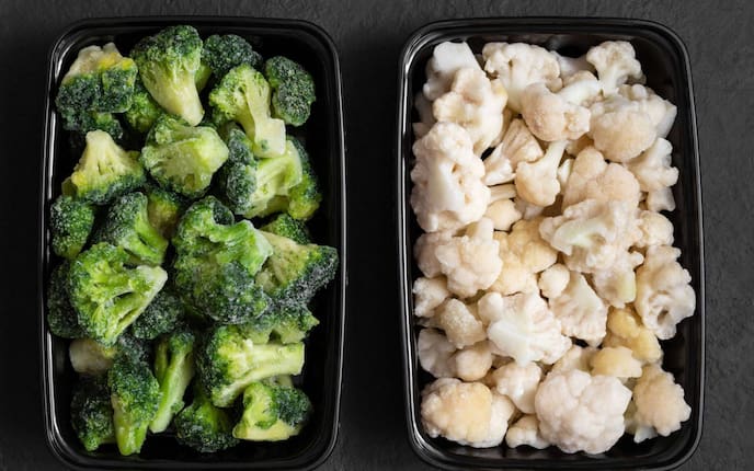 tiefgefrorener Brokkoli und Karfiol und schwarzen Schüsseln