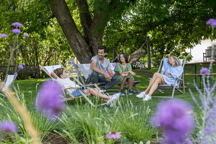 Eine Familie ruht sich auf der grünen Liegewiese aus.
