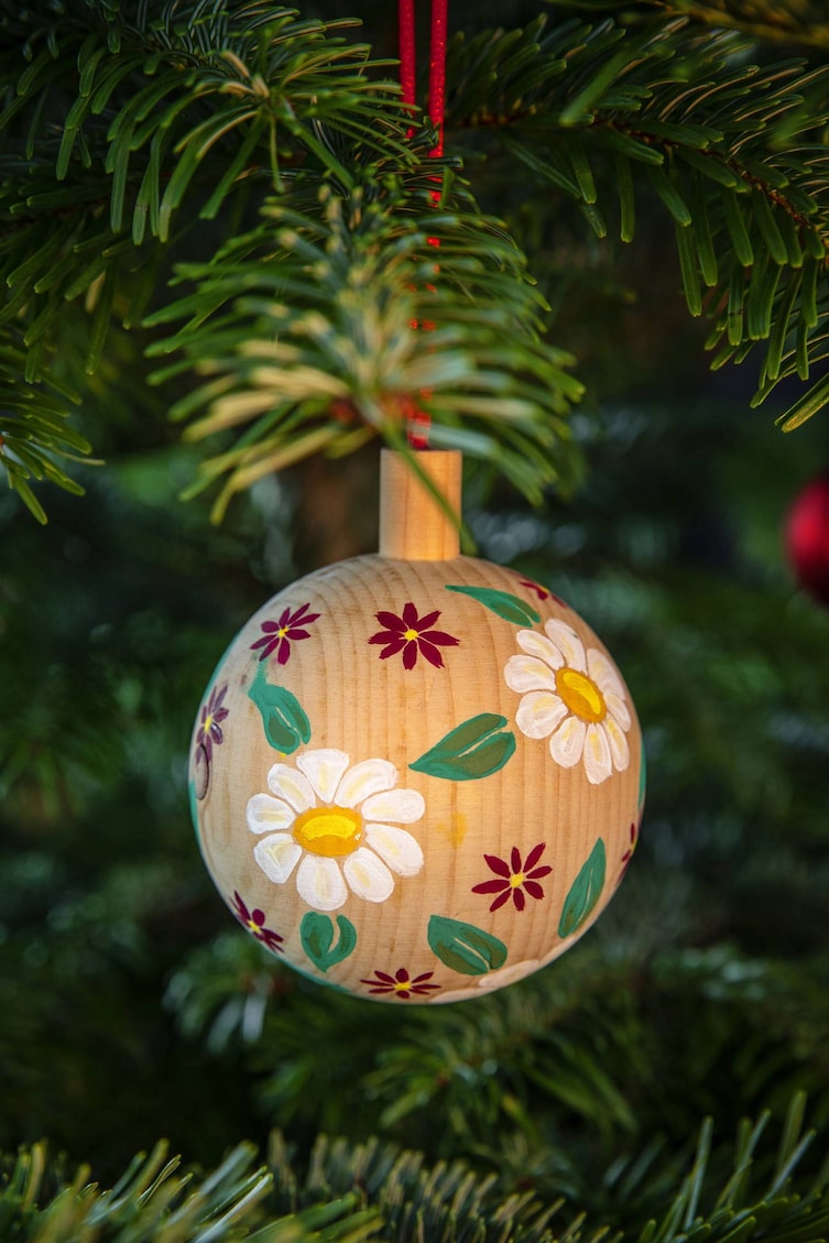 Bauernmalerei für Christbaumkugel aus Holz mit Margeriten und Sternblumen (Bild: Michaela Gabler)
