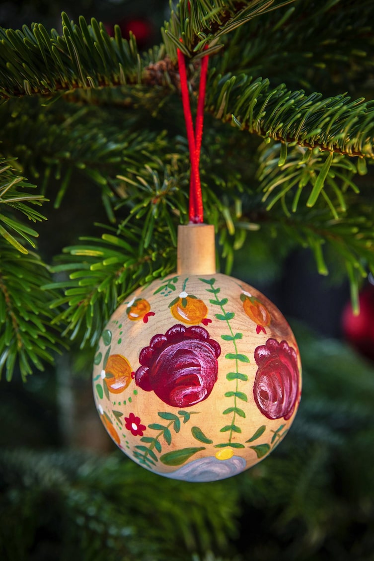 Bauernmalerei für Christbaumkugel aus Holz mit Rosen und Hagebutten (Bild: Michaela Gabler)