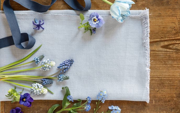 Blaue Blumen, Leinen auf Holztisch