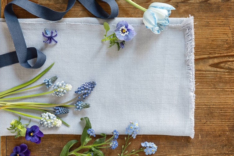 Blaue Blumen, Leinen auf Holztisch