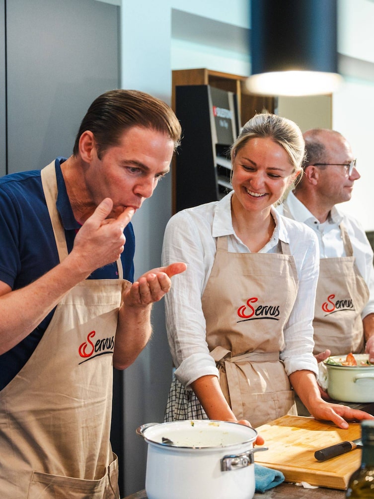 Paula Bründl neben einem Teilnehmer der sich den Finger abschleckt.