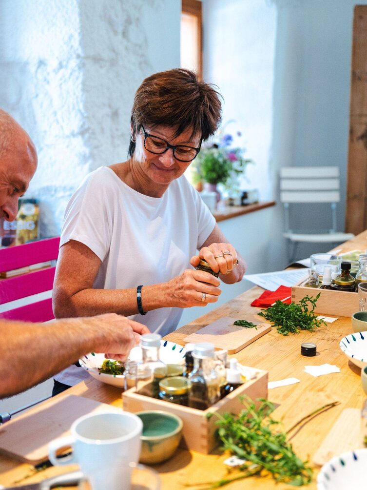 Eine Frau dreht ein Glas ihrer Naturapotheke zu.