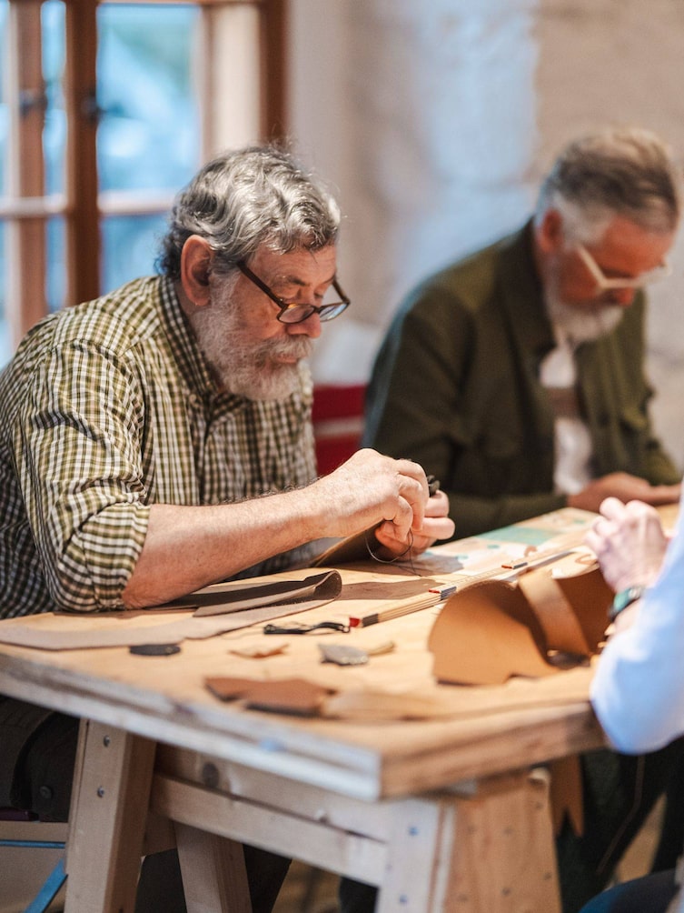 Ein Mann näht seine eigenen Schuhe.