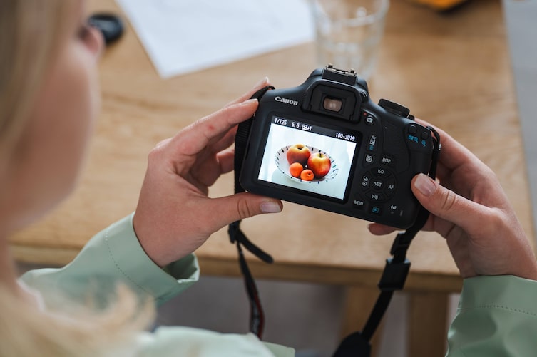 Frau hält Foto in die Kamera.