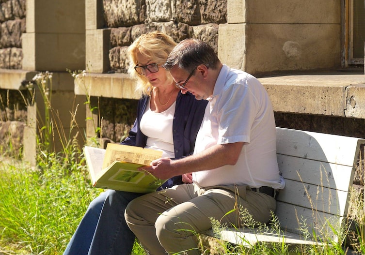 Christof Thöny und Rebecca Hahn blättern im Fotoalbum am Bahnhof Hintergasse