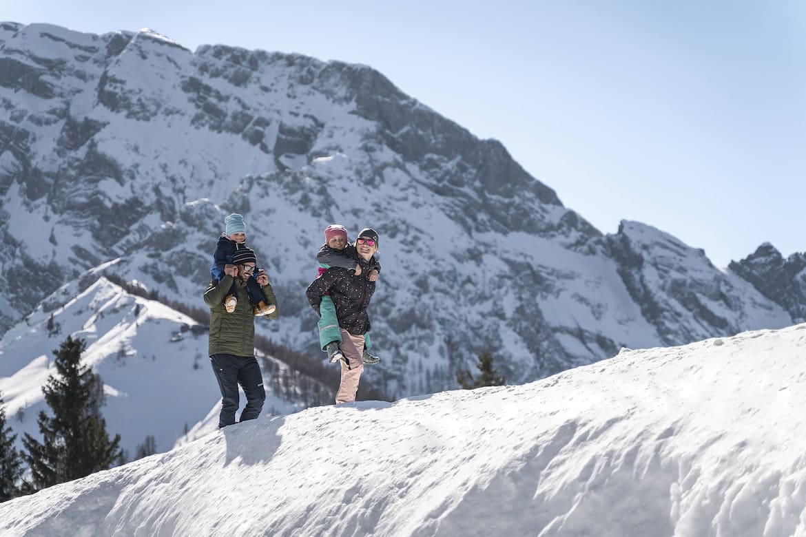 Eine Familie geht im Schnee entlang. Sie sind in Berchtesgaden.