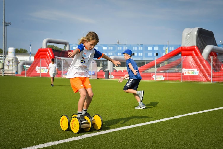 Eine Gruppe Kinder balanciert auf einem Slackline-Parkour während des „Servus Bewegt Kinder Aktionstags“.