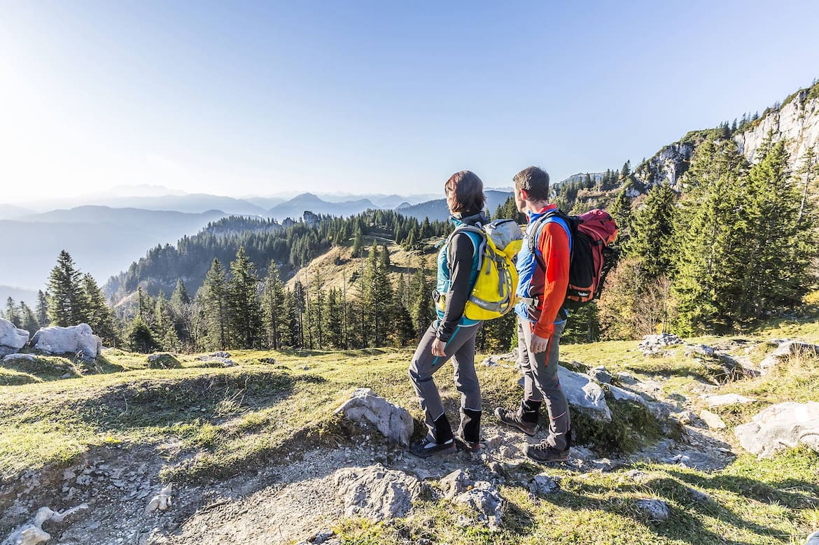 Eine Frau und ein Mann wandern in Chiemsee an der Kampenwand.