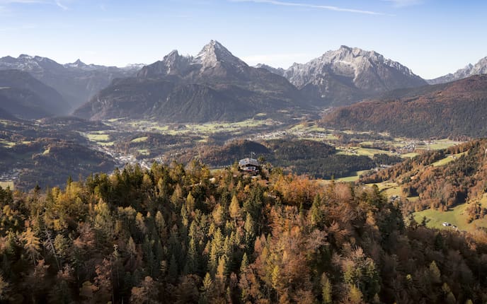 Panoramablick im Herbst über das Berchtesgadener Land mit buntem Laubwald, Watzmann und umliegenden Berggipfeln.