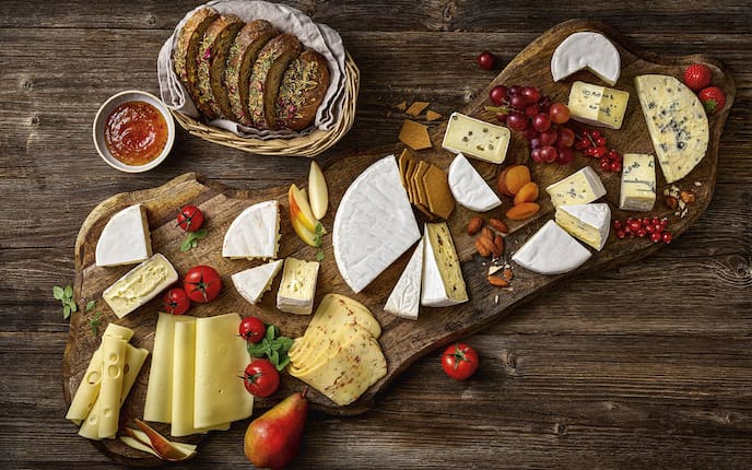 Eine Käseplatte auf der unterschiedliche Käsevariationen zu sehen sind.