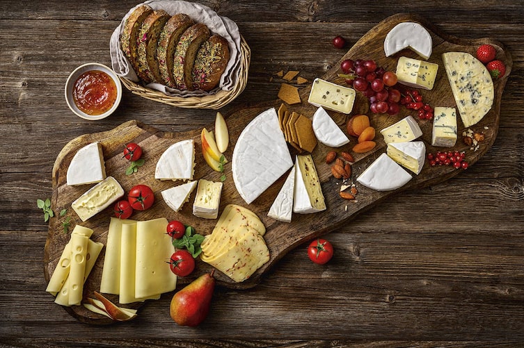Eine Käseplatte auf der unterschiedliche Käsevariationen zu sehen sind.