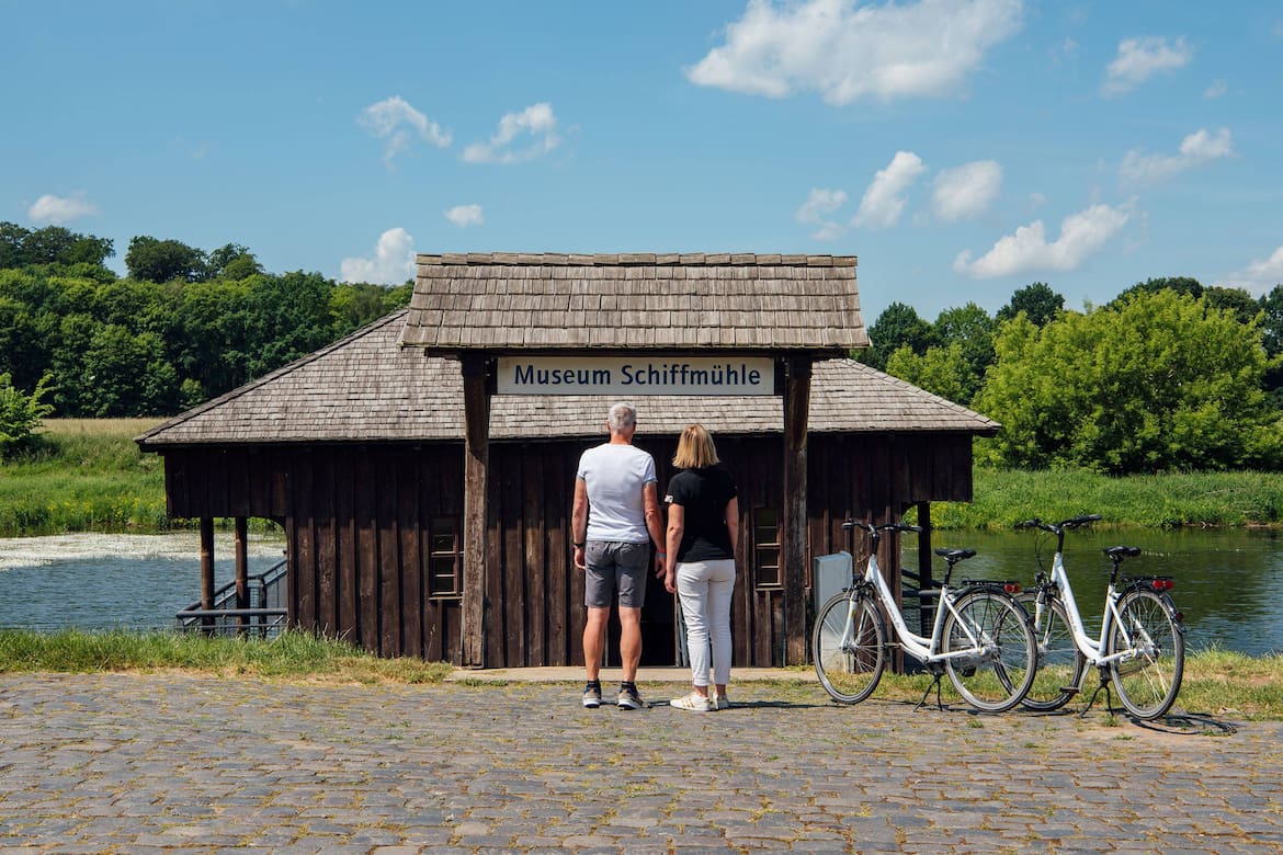 Eine Frau und ein Mann stehen vor dem Museum Schiffmühle.