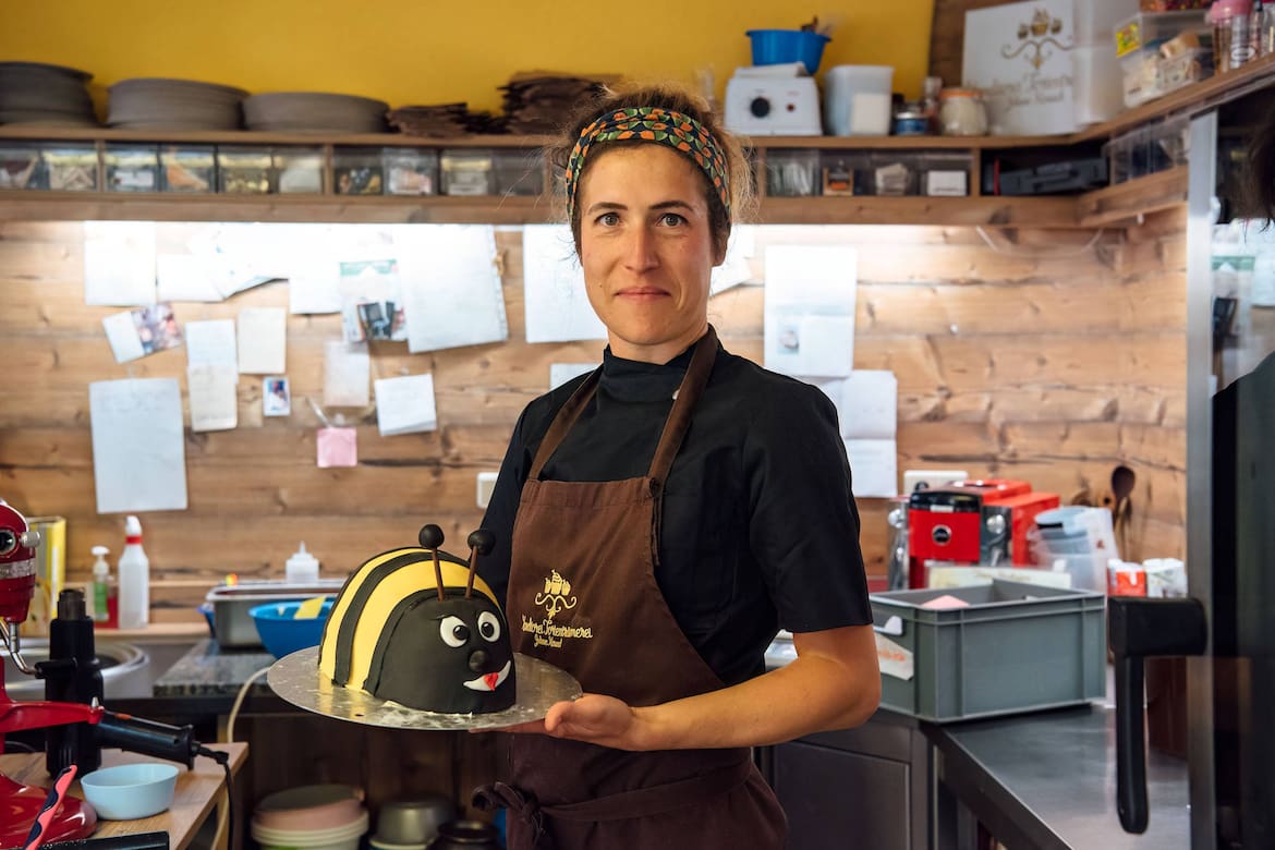 Eine Bäckerin der Tortenträumerei in Grimma hält einen Bienenkuchen.