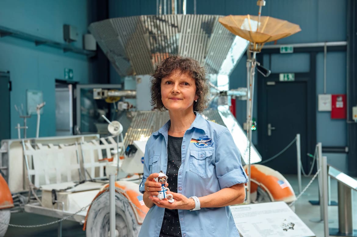 Eine ältere Frau steht inmitten des Deutschen Raumfahrtmuseums.