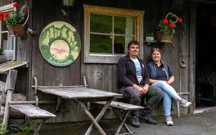Theresa Dagn und ihr Ehemann Leonhard sitzen vor ihrer Latschenkieferbrennerei.