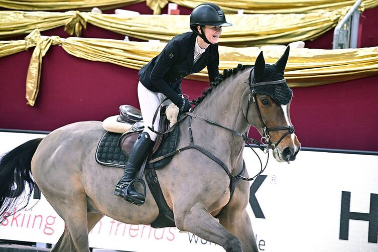 AMADEUS HORSE INDOORS: Eine junge Reiterin feiert ihre gelungene Vorführung mit einem strahlenden Lächeln.