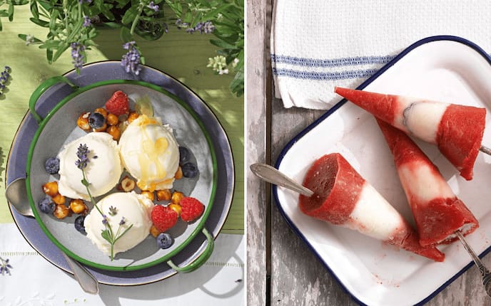 Zwei Eisvariationen nebeneinander: links drei Kugeln cremiges Lavendel-Eis mit Lavendelblüten, Himbeeren, Heidelbeeren und karamellisierten Haselnüssen auf einem grünen Emaille-Teller; rechts drei rot-weiße Erdbeer-Eislutscher am Stiel auf einem weißen Emaille-Tablett, auf rustikalem Holzuntergrund.