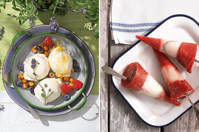 Zwei Eisvariationen nebeneinander: links drei Kugeln cremiges Lavendel-Eis mit Lavendelblüten, Himbeeren, Heidelbeeren und karamellisierten Haselnüssen auf einem grünen Emaille-Teller; rechts drei rot-weiße Erdbeer-Eislutscher am Stiel auf einem weißen Emaille-Tablett, auf rustikalem Holzuntergrund.