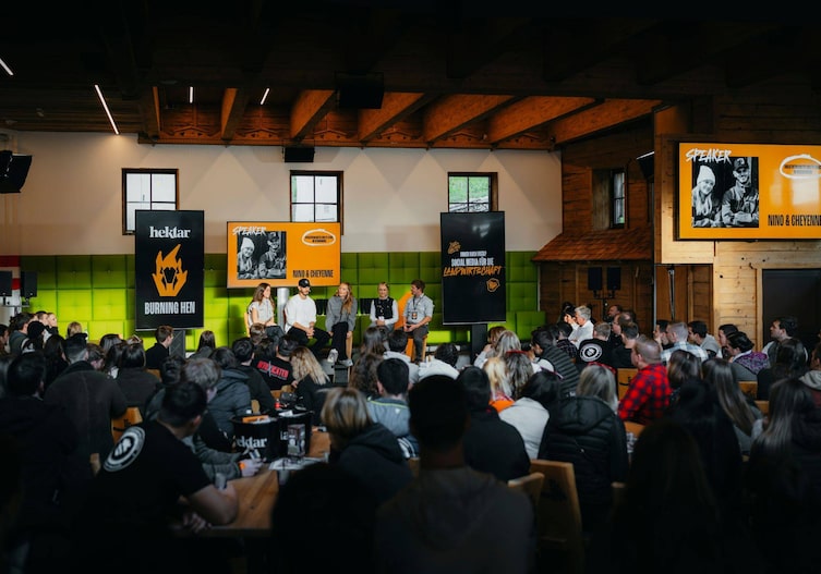 Ein großes Publikum sitzt vor einem Podium, das diskutiert.