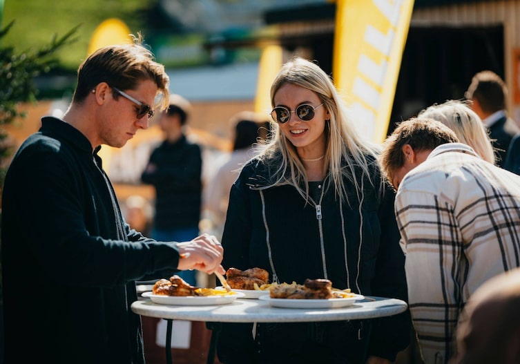 Ein Mann und eine Frau die Grillhendl essen.