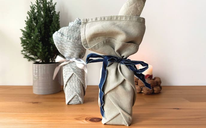 Ein zylindrisches Geschenk in einer Stoffserviette eingepackt