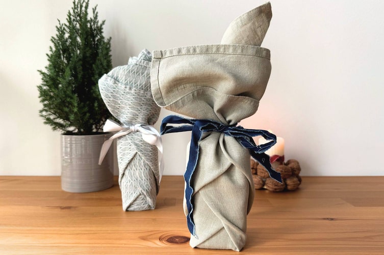 Ein zylindrisches Geschenk in einer Stoffserviette eingepackt