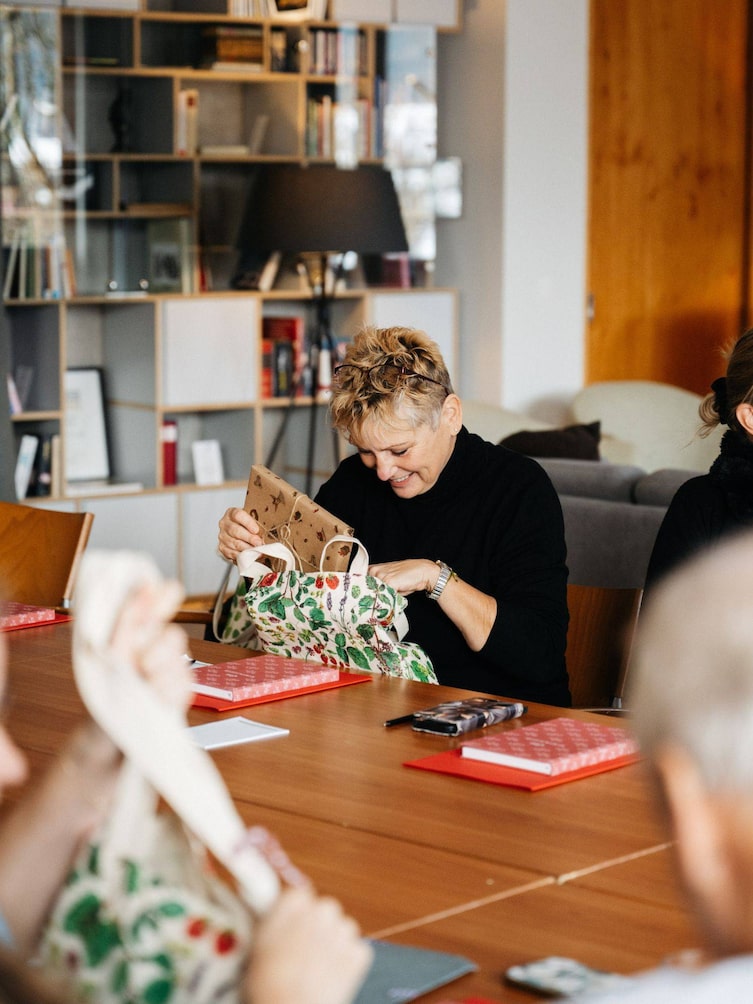 Teilnehmerin die die Servus-Goodiebag öffnet.