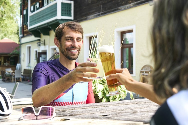 Radfahrer stoßen nach der Tour im Gastgarten des Thalberghofs an.