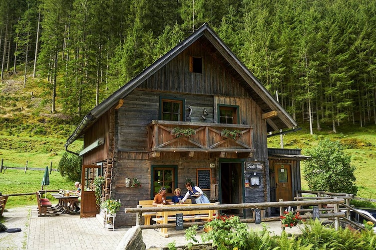 Außenansicht der urigen Sondl-Alm in Rohrmoos bei Schladming, umgeben von Wald und Natur.