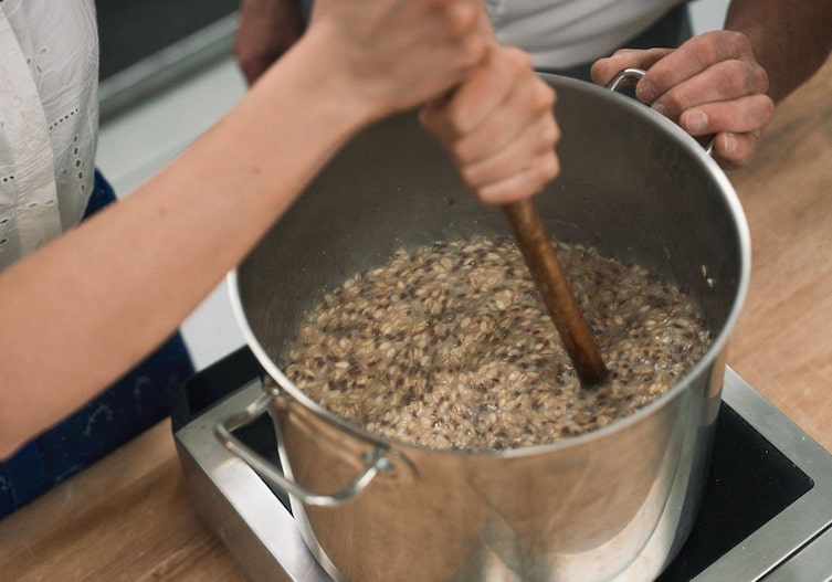 Paula Bründl rührt beim Unterbäck in dem großen Topf mit Kochstück.