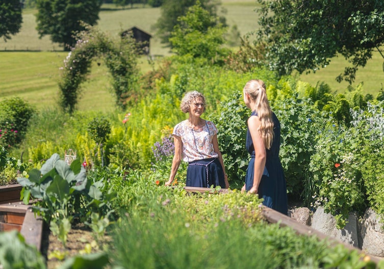 Rosi Rainer führt Köchin Paula Bründl durch ihren üppigen Kräutergarten.