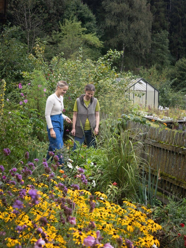 Sabine Schrott und Paula Bründl bei der Suche nach frischen Kräutern am Felderhof in Südtirol.