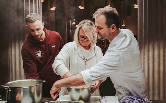 Marko Arnautović, Mama Gabriela von Marko Arnautović, Starkoch Fritz Grampelhuber kochen gemeinsam Faschierte Laibchen. Sie stehen in der Küche und rühren gerade die Masse dafür an.