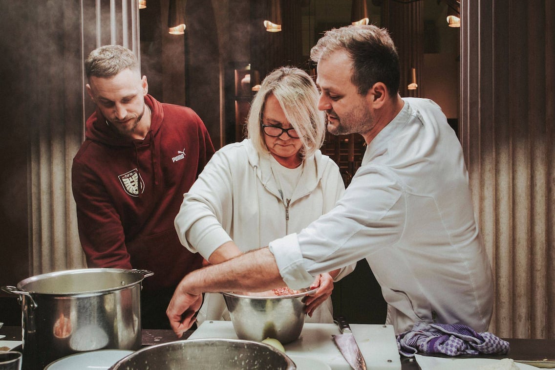 Marko Arnautović, Mama Gabriela von Marko Arnautović, Starkoch Fritz Grampelhuber kochen gemeinsam Faschierte Laibchen. Sie stehen in der Küche und rühren gerade die Masse dafür an.