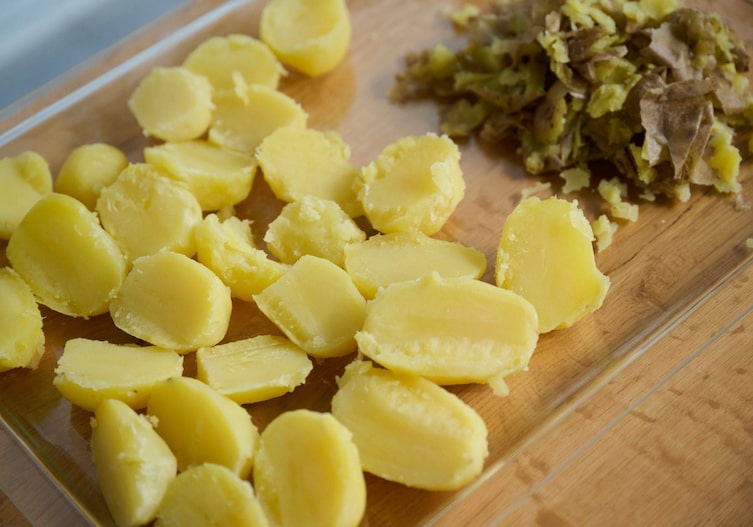 Halbierte, gekochte Erdäpfel liegen zum Ausdampfen auf einer Platte.