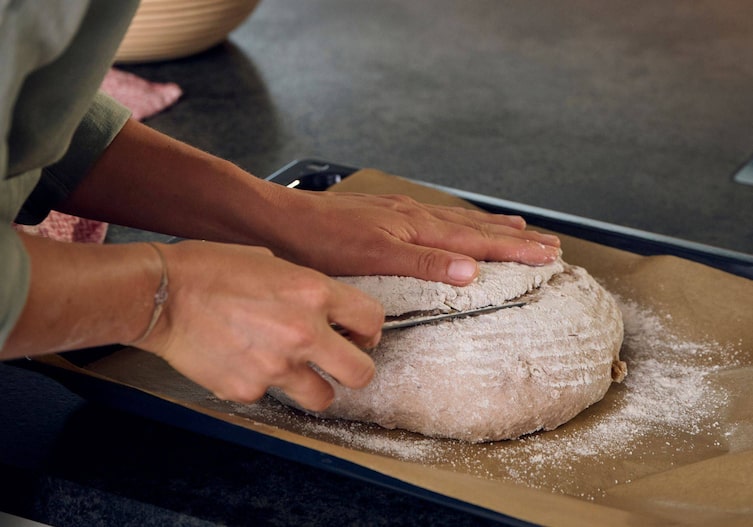 Paula Bründl schneidet das Brot an der Oberfläche ein.
