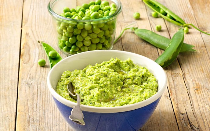 Erbsenpesto, Glasschüsserl, Löffel, Erbsenschoten, Holztisch