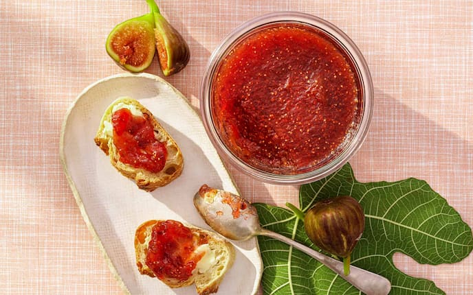 Feigenmarmelade mit Gewürzen, Teelöffel, Butter, Baguette, Teller, Glas, Feigenblatt