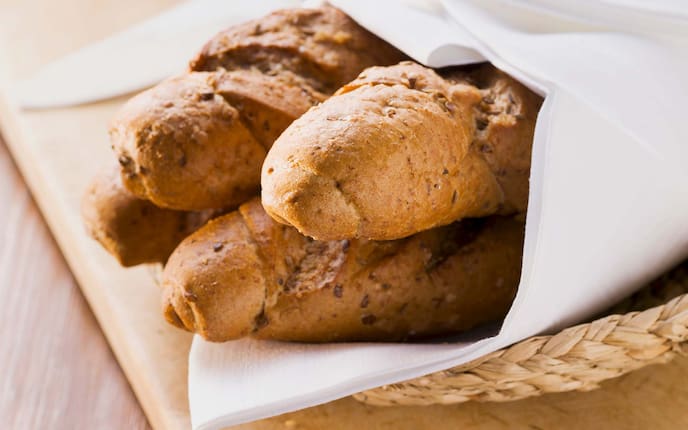 Kornspitz, Sesam, Stoffserviette, Holztisch, Brotkorb