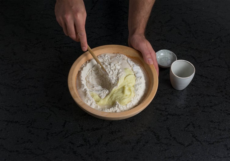 Mehl, Tasse, Kochlöffel, Holzschüssel, Hände