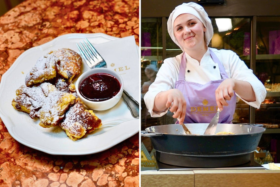 Demel-Kaiserschmarrn auf weißem Teller: goldbraune Schmarren-Stücke mit Staubzucker bestreut, dazu ein Schälchen dunkles Kompott und eine Silbergabel auf Marmortisch, Demel-Serviette im Hintergrund. Konditorin in weißer Kochuniform und lilafarbener Demel-Schürze bereitet Kaiserschmarrn in einer schwarzen Eisenpfanne in der Wiener Konditorei Demel zu.