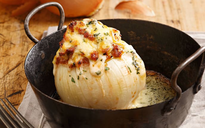 Gefüllte Zwiebel mit Käsesauce, Reindl, Besteck, Holztisch