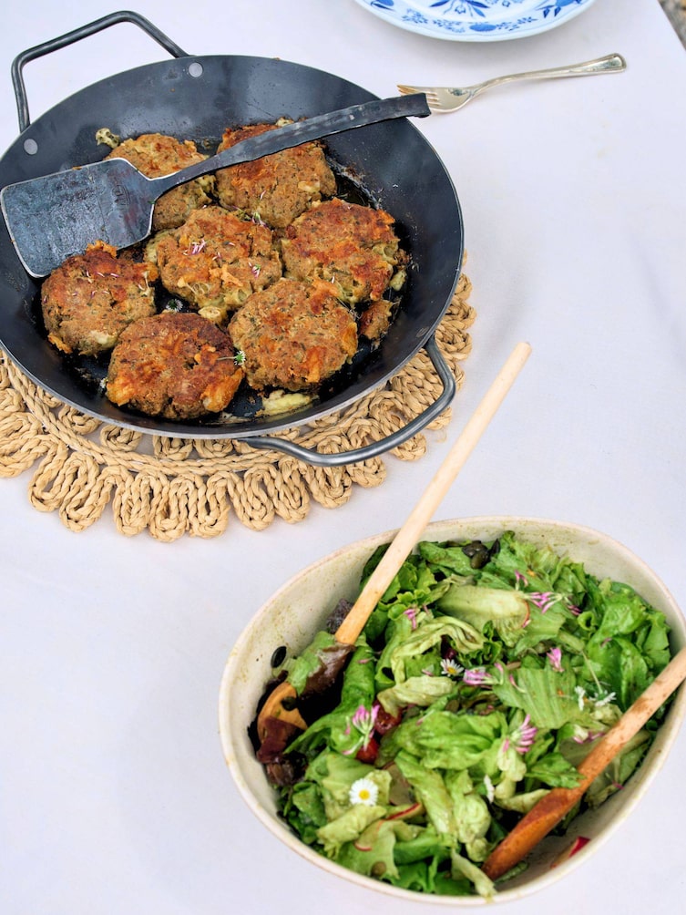 Fertig angerichtete Kaspressknödel in einer Gusseisenpfanne mit grünem Salat